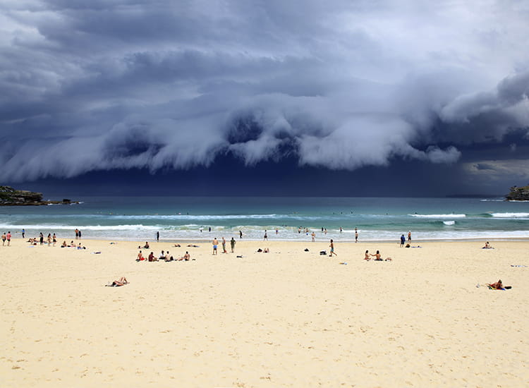 photo of storm clouds rolling in over a beach from the ocean